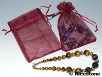 Pochettes Organza 12x18 cm bordeaux présenté avec un bijoux